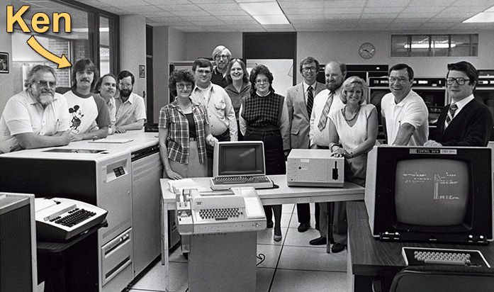 Black & white group photo of staff with Cyber 171 & other computer equipment. Ken is highlighted.