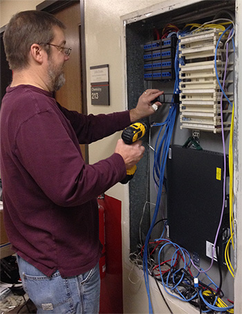 Photo: Ken working on a switch with a drill in hand.