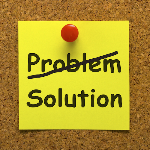 Stick note pinned to a cork board Text: Problem - Solution
